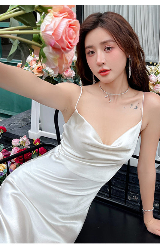 Woman in a white satin dress with flowers in the background