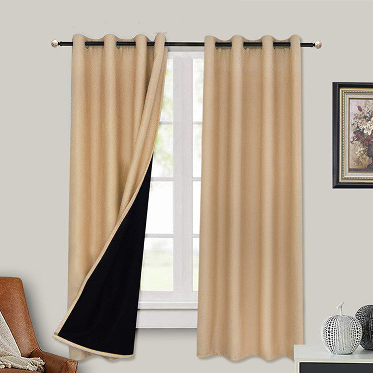 A pair of beige full blackout curtains with black lining, displayed in a room setting, showcasing both sides of the curtains with a visible window in the background.