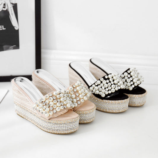 Pair of embellished platform sandals on a white surface with a blurred background