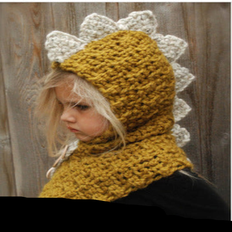 A baby wearing a beige knitted hat with a hood that has a bear face design and wooden button details.