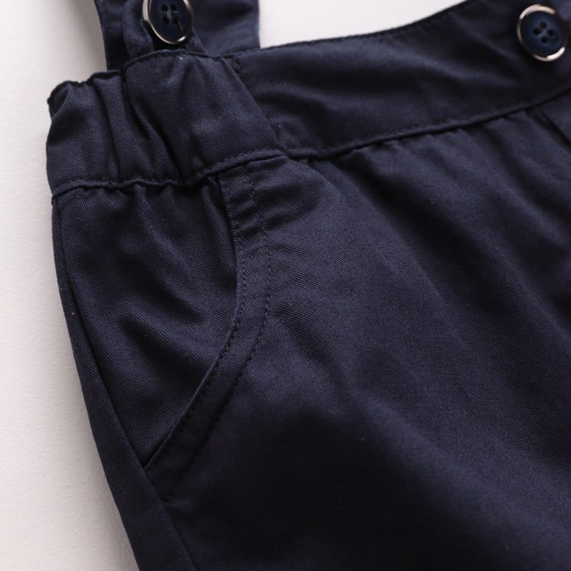 Close-up of navy blue overalls with button details on a white background