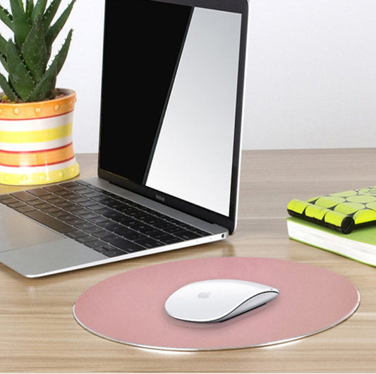 Laptop with pink mouse pad on a wooden desk