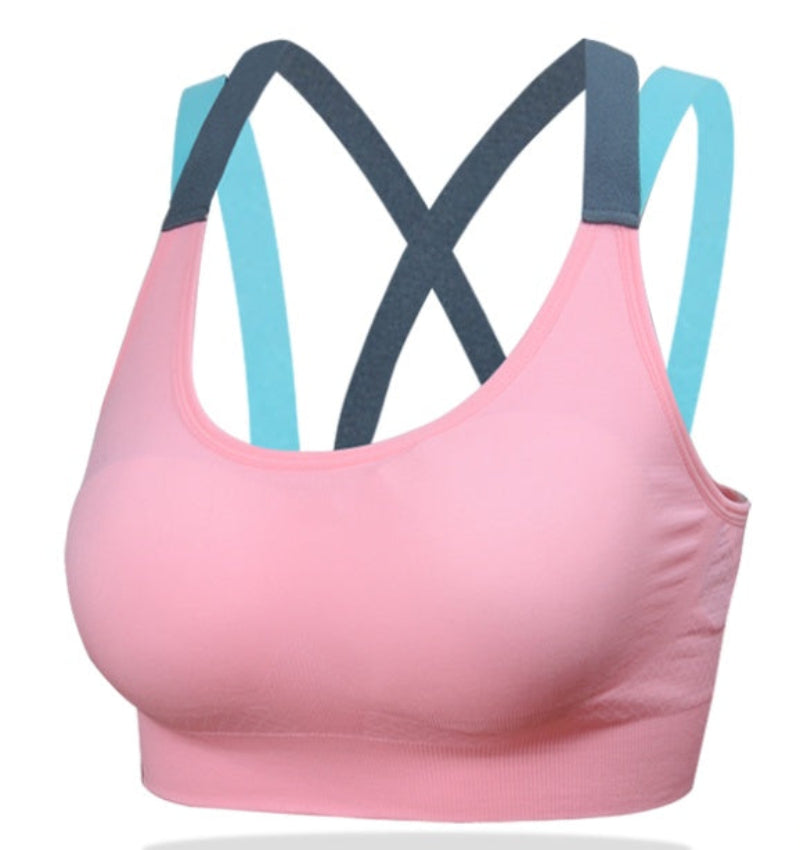 A woman wearing a sports bra in gray, with additional sports bras shown in pink, black, and turquoise colors.