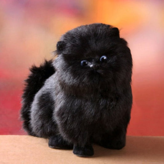 Plush toy of a black Pomeranian dog on a blurred background