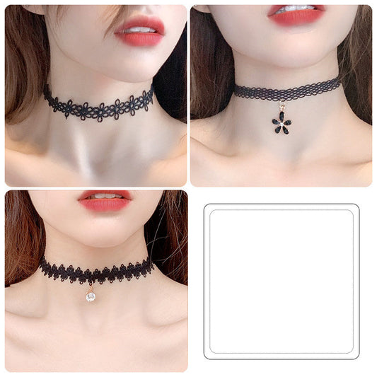 Black lace chokers with floral and diamond designs on a person's neck.