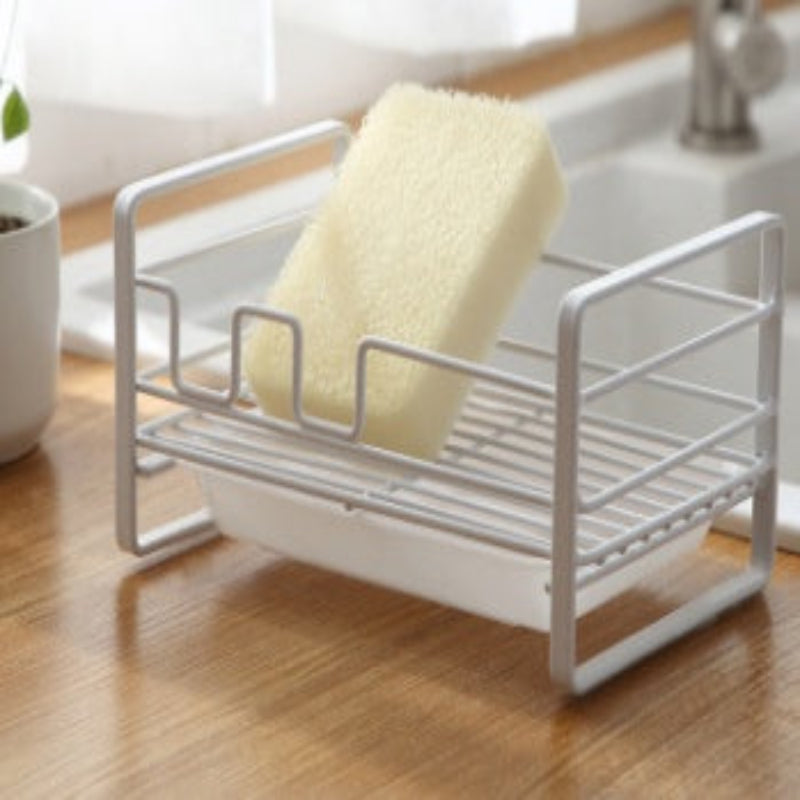 White dish rack with a yellow sponge on a wooden surface
