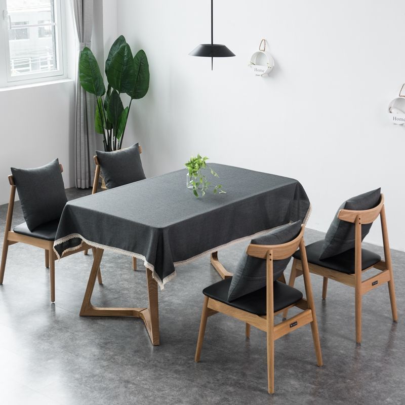 A green waterproof tablecloth on a rectangular table with a close-up of the fabric texture.