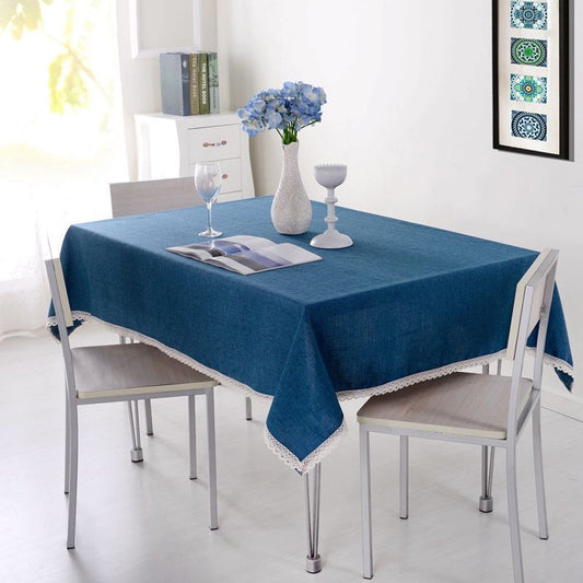 A green waterproof tablecloth on a rectangular table with a close-up of the fabric texture.