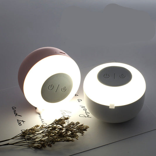 Two night light Bluetooth speakers with one illuminated on a surface.
