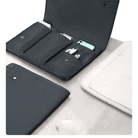 Black travel pouch with compartments containing electronic accessories on a light gray surface.