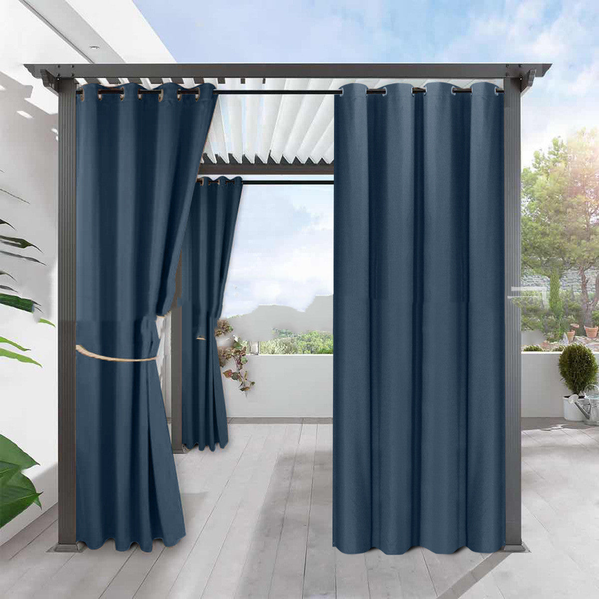 A set of light blue linen blackout curtains installed on a pergola, with a garden visible in the background.