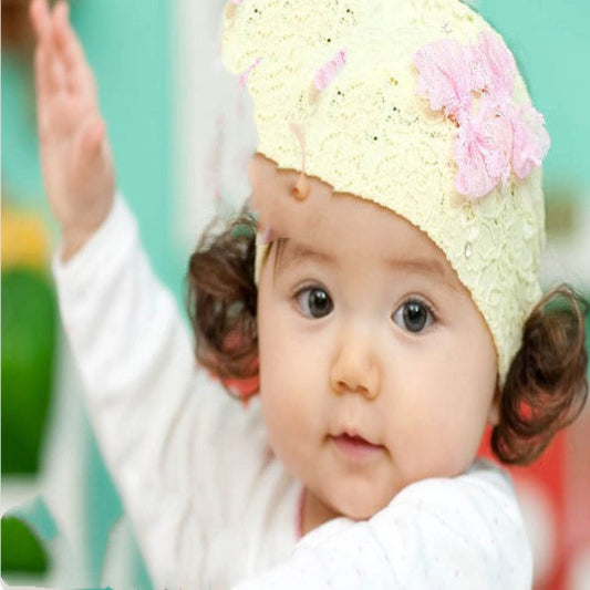Child wearing a yellow knit hat with a pink flower on a blurred background