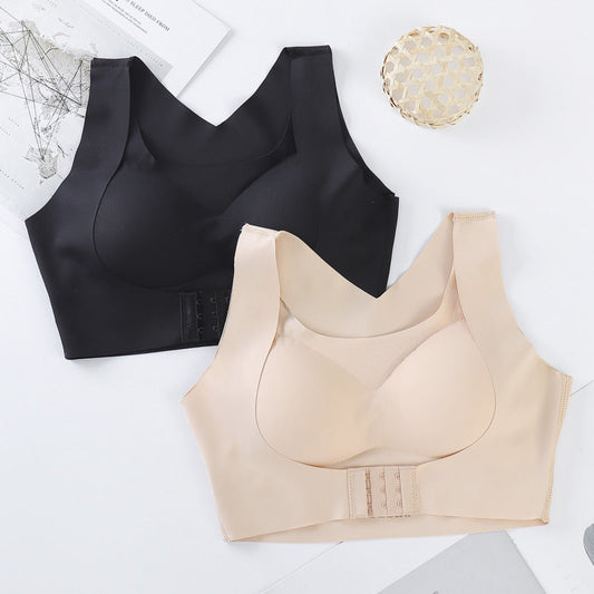 Black and beige bras on a white surface with a magazine and decorative item.