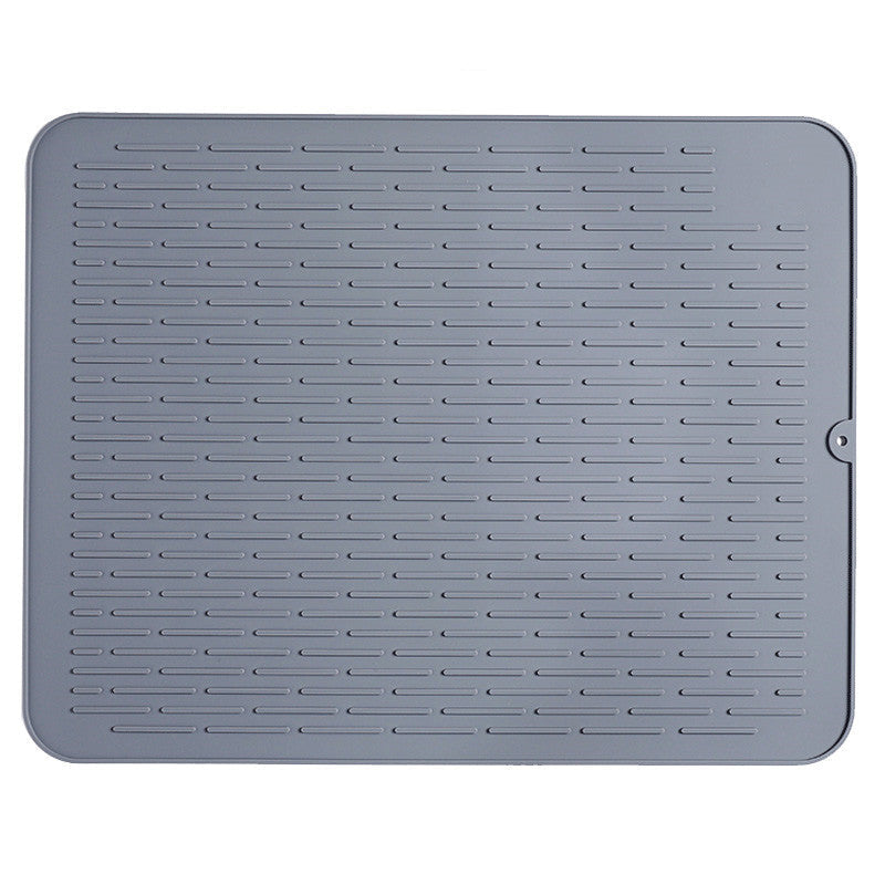 A gray silicone mat placed on a kitchen counter, with tableware such as a white bowl, a white cup with blue stripes, and two glasses being dried on top of it.