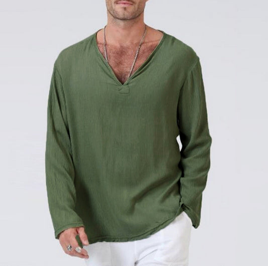 Man wearing a green long-sleeve shirt and white pants on a plain background