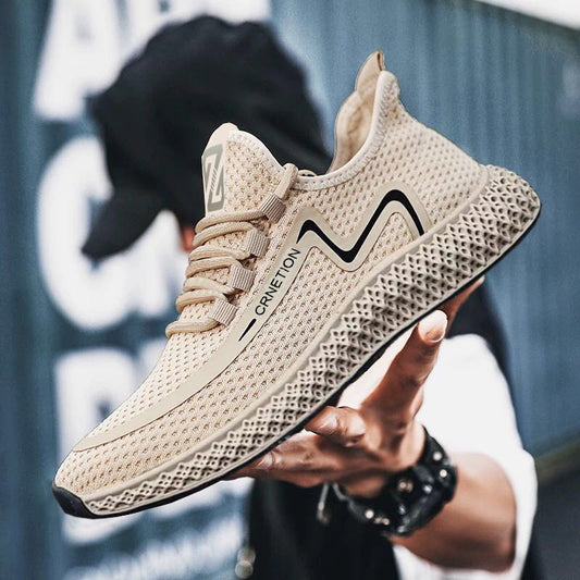 Beige sneaker with black accents held by a hand against a blurred background