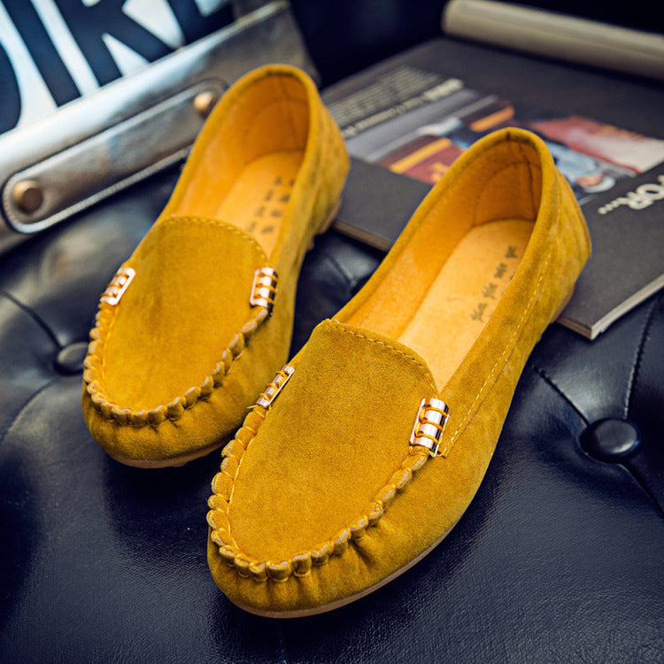 Yellow loafers with gold accents on a dark surface