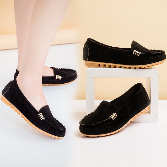 Black loafers with gold accents on a white surface