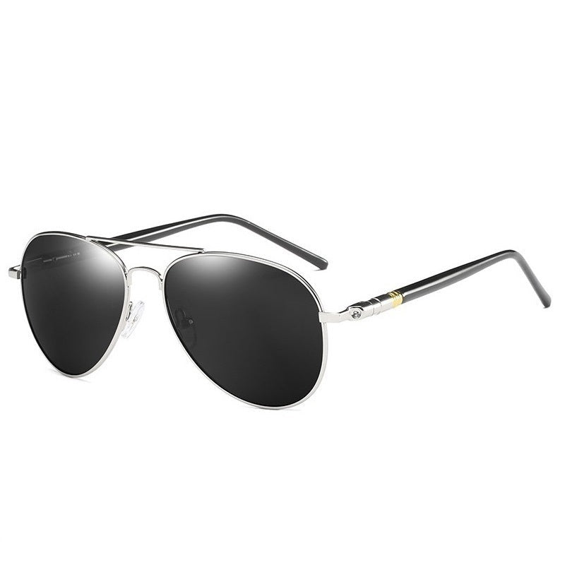 A pair of sunglasses with a black frame and polarized lenses resting on a textured grey surface.