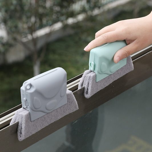 Window cleaning tool with gray sponges attached to a window frame, with a blurred outdoor background.