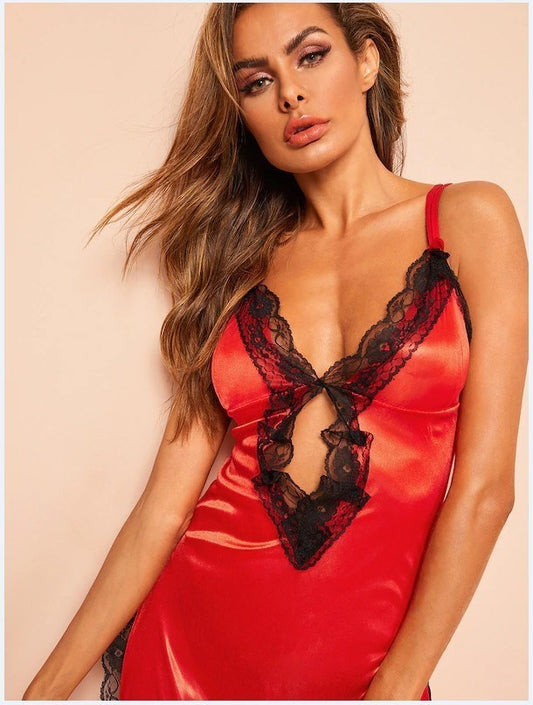 Woman wearing a red satin nightgown with black lace details against a beige background