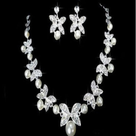 A bridal jewelry set including a necklace, earrings, and a headpiece, featuring white pearls and silver-colored metal with a floral design.