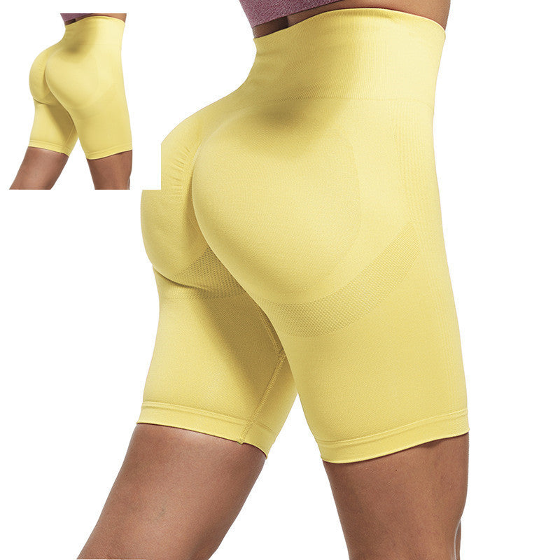 Yellow athletic shorts worn by a person on a white background