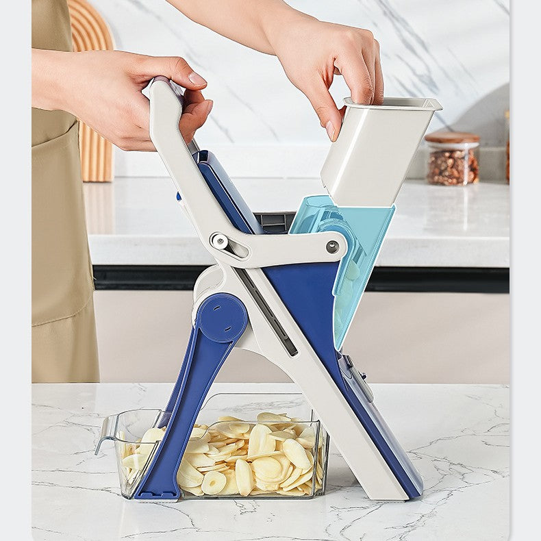 Person using a blue and white mandoline slicer to cut potatoes on a kitchen counter.