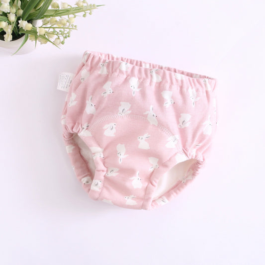 Pink baby bloomers with white floral pattern on a light background
