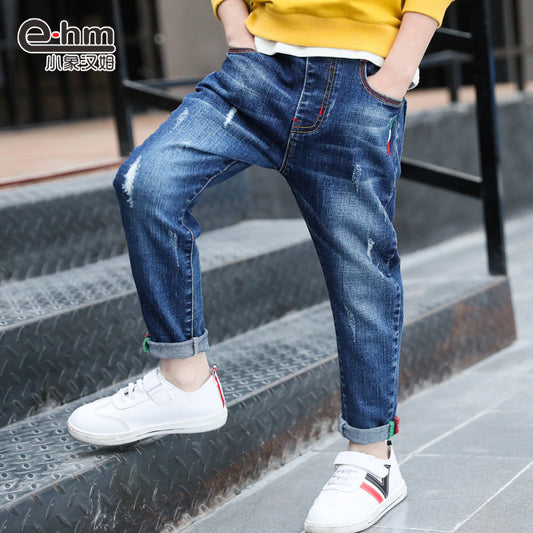 Person wearing blue jeans and white sneakers on a staircase, with 'e-hm' brand logo.