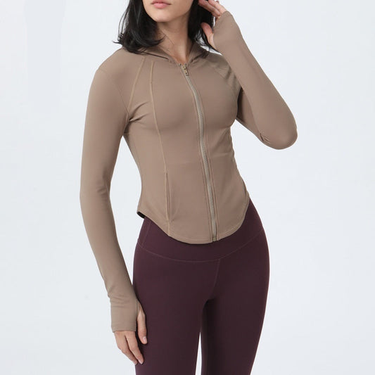 Person wearing a beige long-sleeve top on a plain background