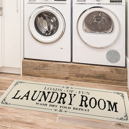 Laundry room with a rug displaying 'Laundry Room' text in front of washing machines.