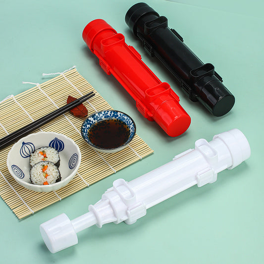 Sushi-making tools on a light green surface with sushi and chopsticks.