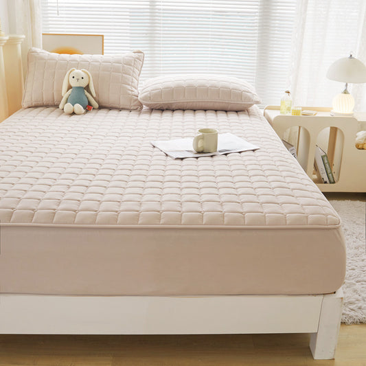 Beige mattress pad on a bed in a bedroom.