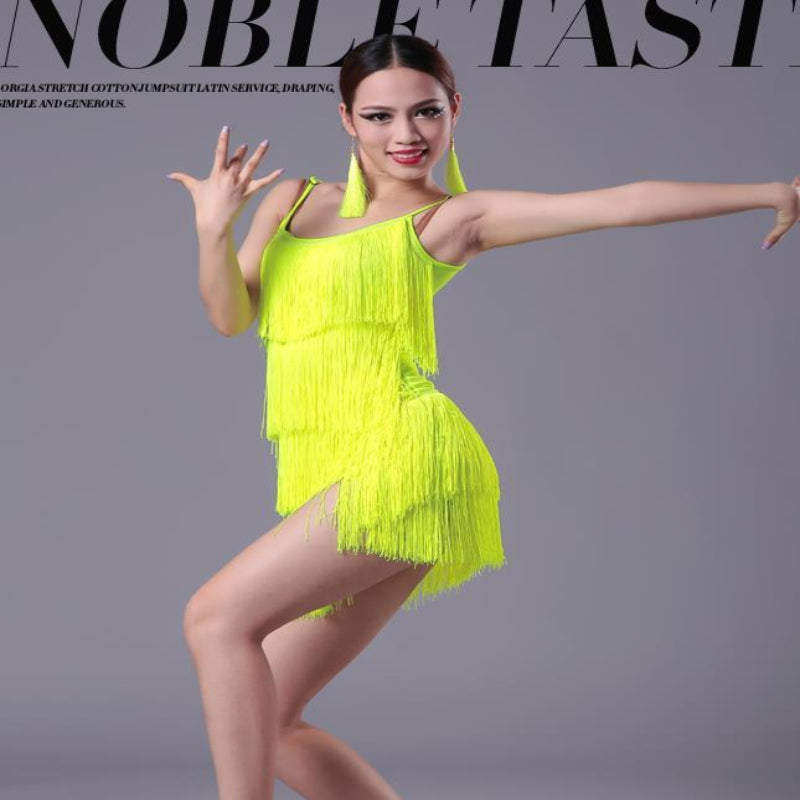 Model wearing a bright yellow fringe dress against a gray background