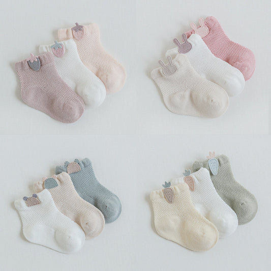 Set of baby socks in various colors on a light background