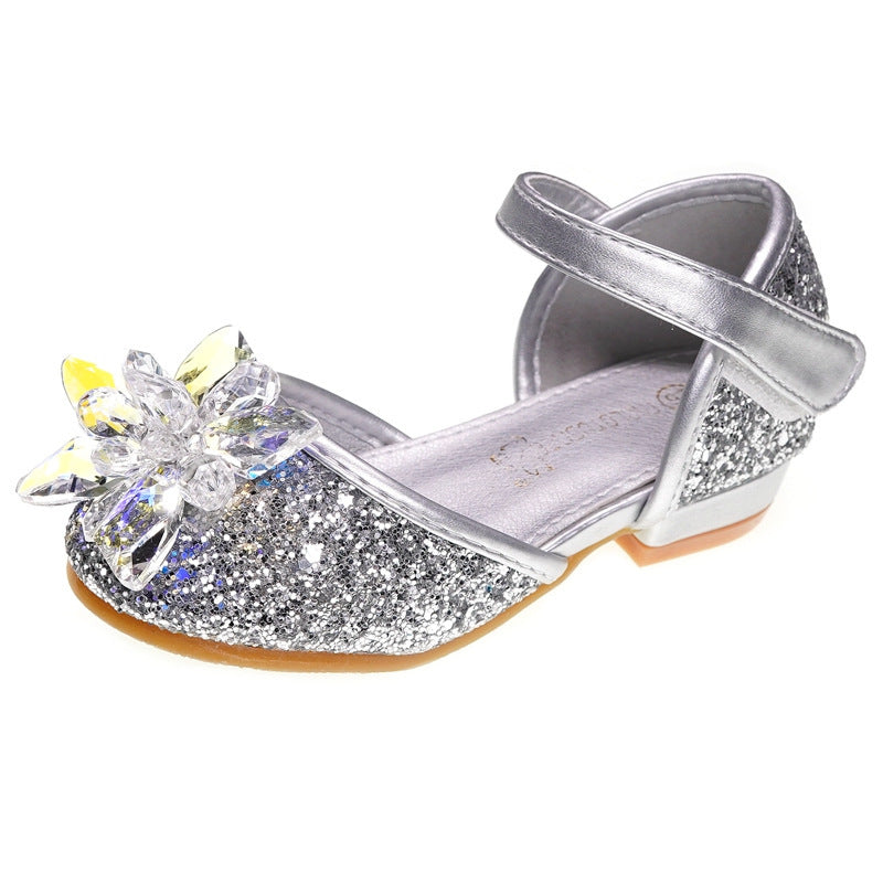 Silver glittery shoe with a decorative flower on a white background