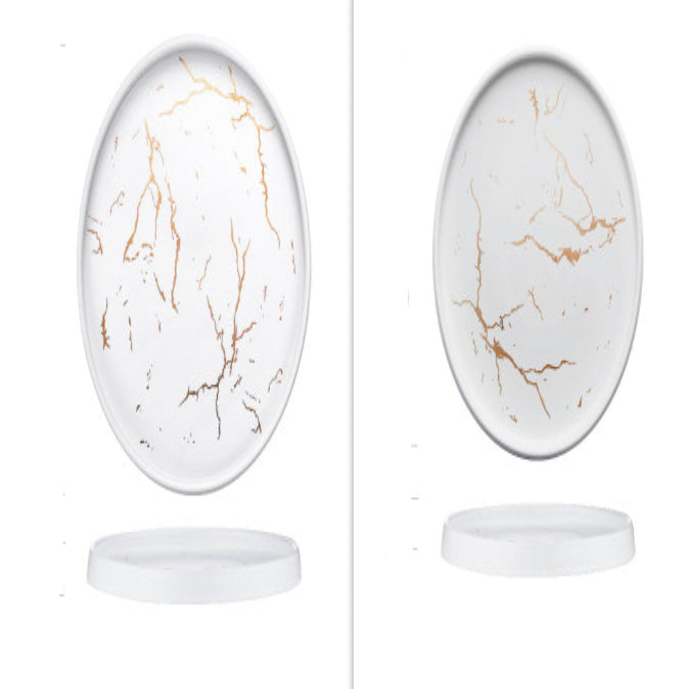 Two porcelain plates, one with a black marble design and another with a white marble design, both featuring gold cracks.