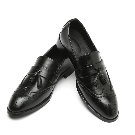 Pair of black leather loafers with tassels on a white background