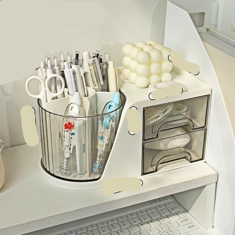 A white rotating desktop storage box with compartments for pens and other office supplies, positioned on a desk.