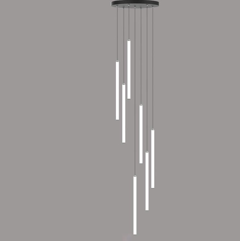 A modern chandelier with multiple vertical light fixtures hanging from the ceiling, with a person walking up a staircase in the background.