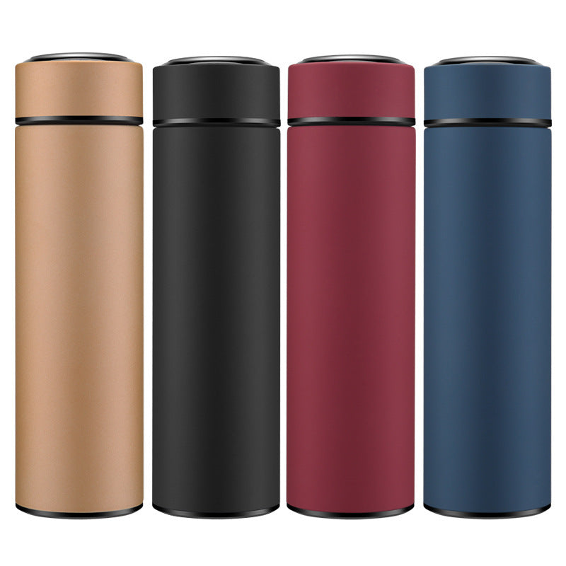 Four stainless steel water bottles in black, red, gold, and blue colors, displayed on a dark surface.