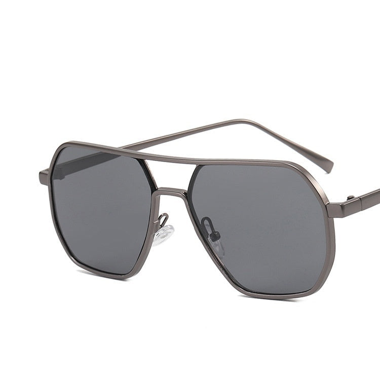 A pair of aviator-style sunglasses with a double beam metal frame and gray lenses, displayed on a wooden surface.