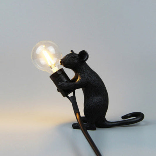 Black rat-shaped lamp holding a light bulb against a plain background.