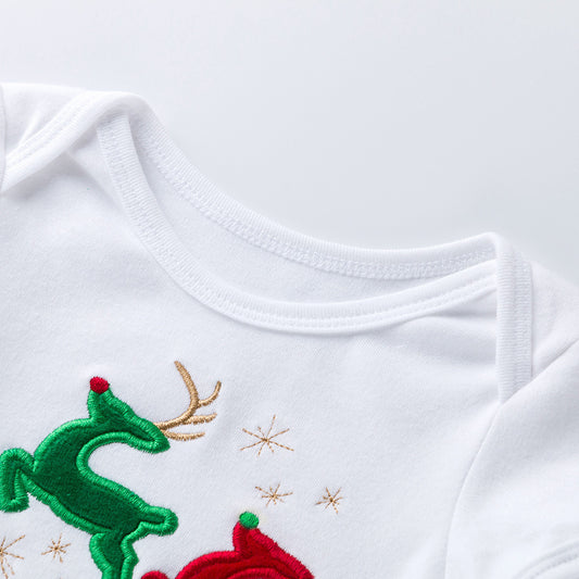 White baby onesie with green reindeer and red sleigh design on a light gray background