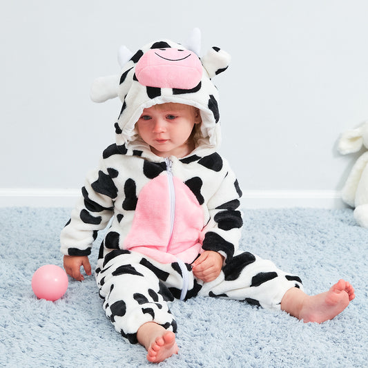 Child wearing a cow-themed onesie with pink accents on a blue carpet.
