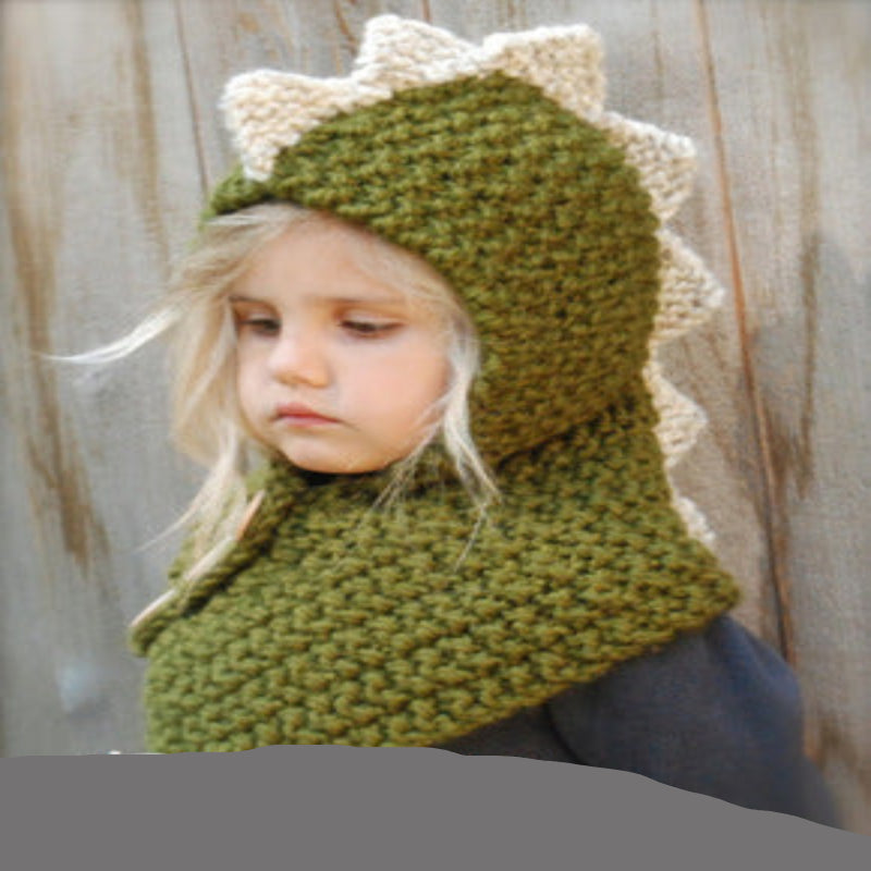 A baby wearing a beige knitted hat with a hood that has a bear face design and wooden button details.