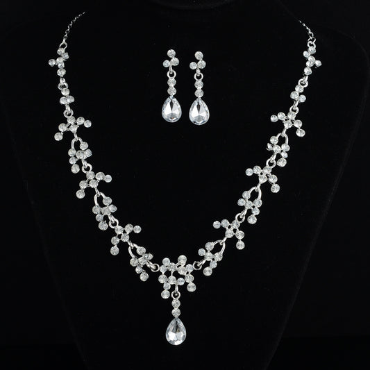 Silver necklace and earrings on a black background