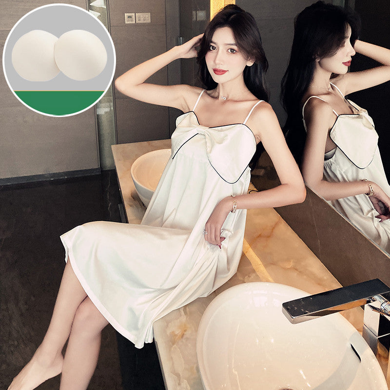 A woman sitting on a bathroom counter wearing a black nightgown with a square neckline and lace details.