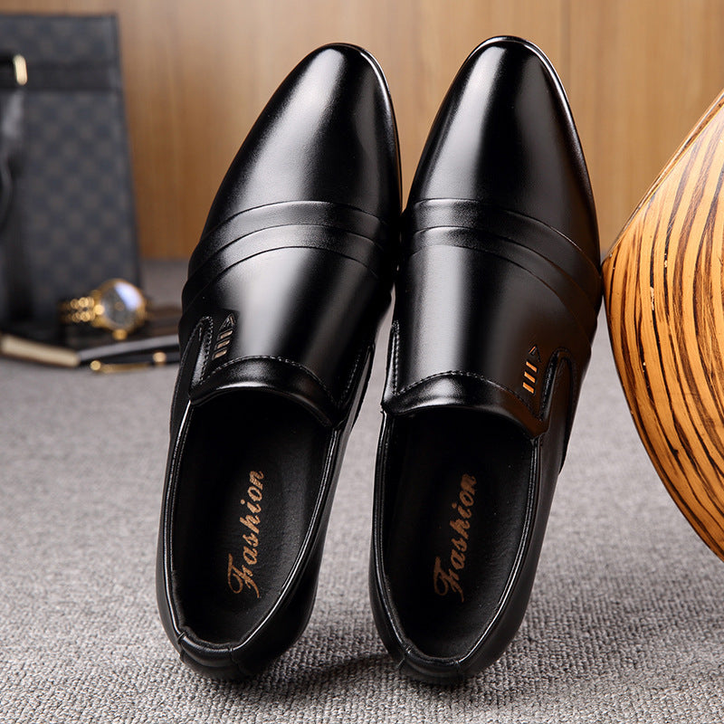 Pair of black dress shoes on a textured surface with a wooden object and black bag in the background.